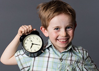 Little boy holding clock