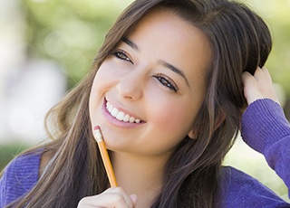 Smiling girl holding pencil