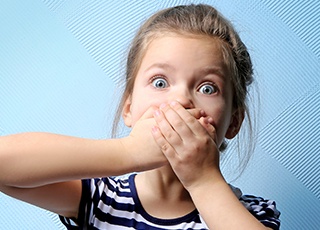 Surprised little girl covering mouth
