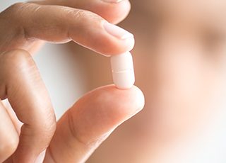 Hand holding oral conscious sedation pill